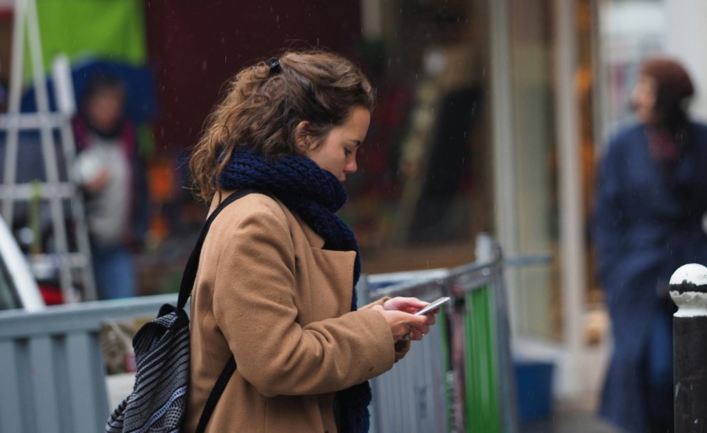 A woman using her phone. Photo by Kazuo ota on Unsplash.