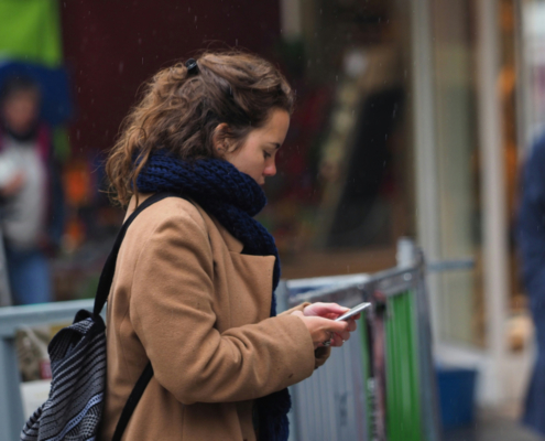 A woman using her phone. Photo by Kazuo ota on Unsplash.
